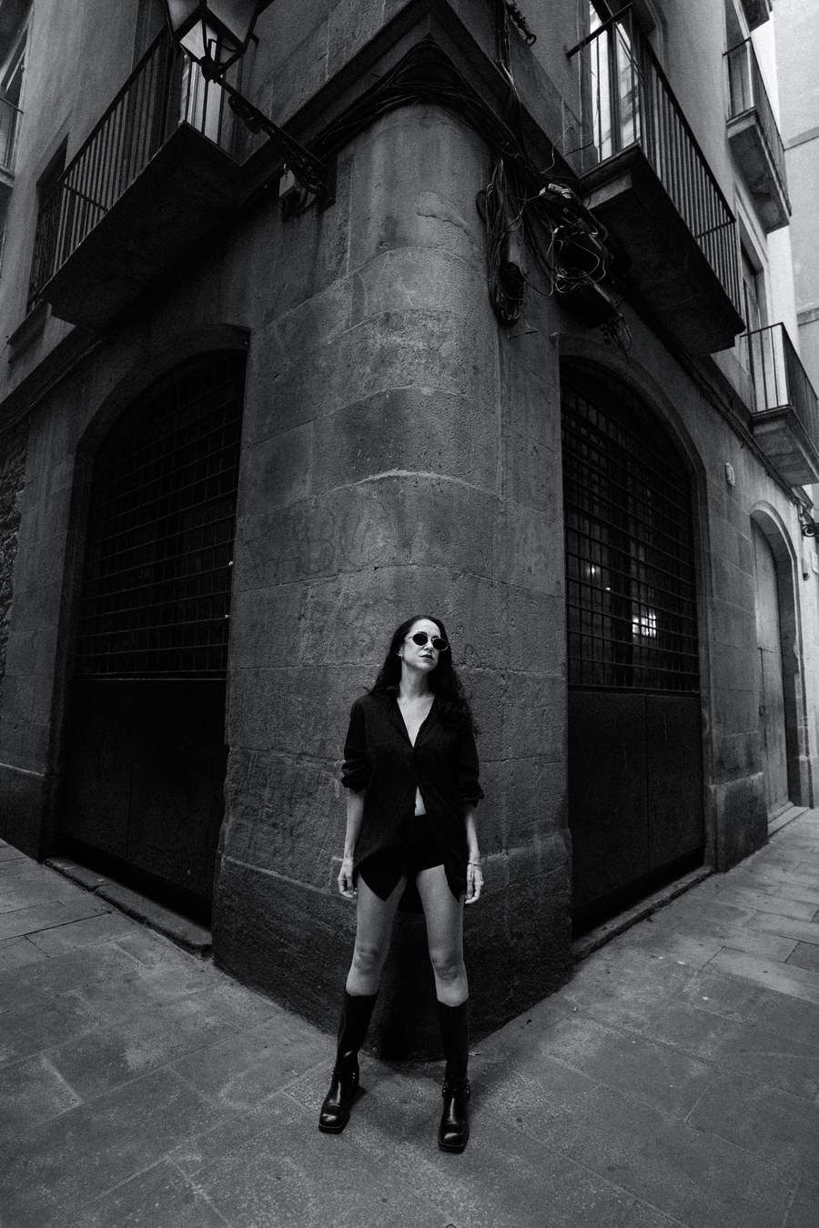Black and white, at the corner of a stone building